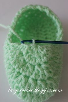 a crocheted green pot holder with a knitting needle in it