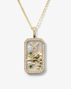 a gold necklace with an image of a lion and emeralds on it's side