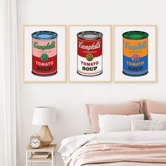 three cans of tomato soup are hanging on the wall above a bed in a bedroom