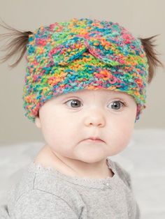 a baby wearing a multicolored knitted hat