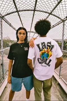 two young men standing on a bridge with one holding the other's arm around his neck