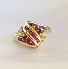 This is a cluster Ruby and diamond ring.  6 pieces of diamonds total weight 0.18 carats.  19 pieces of rubies total weight 0.85 carats.  14kt yellow gold ring weight 4.7 grams. Diamond Cluster Ruby Ring With Diamond Accents, Yellow Gold Cluster Ruby Ring, Cluster Ruby Ring In Yellow Gold, Cluster Ruby Rings With Diamond Accents, Ruby Cluster Rings With Diamond Accents, Red Cluster Diamond Ring In 14k Gold, Red Diamond Cluster Ring In 14k Gold, Cluster Yellow Gold Ruby Ring In Fine Jewelry Style, Gold Cluster Multi-stone Diamond Ring