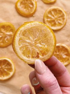 a hand holding an orange slice up to the camera