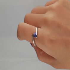 Gracefully coiling around the finger, this tanzanite triangle bypass ring exudes super-natural beauty. A tanzanite gemstone ring reveals tonal depth ranging from lilac-blue to deep-blue violet with exceptional contrast in sterling silver. | Tanzanite Triangle Bypass Ring | Sterling Silver | White | Size 7 | Helzberg Diamonds Triangle Tanzanite Ring, Blue Engagement Ring, Measure Ring Size, Lilac Blue, Country Rings, Tanzanite Jewelry, Helzberg Diamonds, Womens Ring, Tanzanite Stone