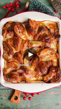 a casserole dish with ham and cheese in it on a wooden table next to christmas decorations