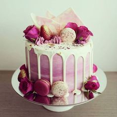 a pink cake with white icing and flowers on top