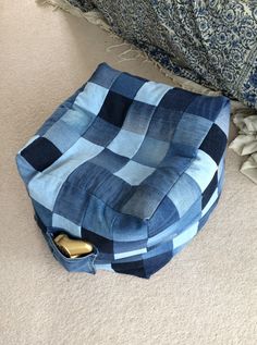 a blue and white checkered blanket sitting on the floor next to a gold object