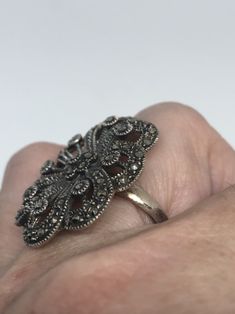 Vintage ring surrounded by Swiss cut fine Marcasite Sterling silver Size 7.5 can be sized by my jeweler. His service charge is $10- $15 All rings are shipped in a nice gift box. Check out our over a THOUSAND great reviews Engraving is $4 per letter and is not always perfect depending on the piece. It can take a few days if the jeweler is busy. This is payable to Paypal Judithsltd@gmail.com Victorian Sterling Silver Diamond Ring, Silver Marcasite Ring, Marcasite Ring Stamped 925, Antique Marcasite Round Jewelry, Victorian Marcasite Jewelry For Anniversary, Vintage Marcasite Ring Stamped 925, Silver Open Cluster Ring As Gift, Marcasite Ring For Anniversary, Victorian Silver Diamond Ring With Gemstone