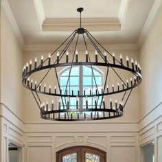 a large chandelier hanging from the ceiling in a room with white walls and windows