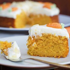 a piece of carrot cake on a plate with a fork next to it and the rest of the cake in the background