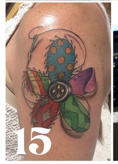 a woman's arm with a colorful tattoo on it and a button in the center