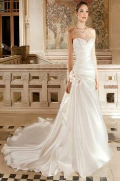 a woman in a white wedding dress posing for the camera