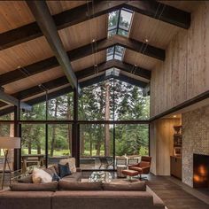 a living room filled with furniture and a fire place in front of a large window