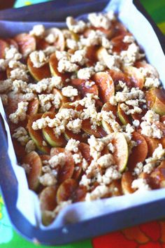 a blue dish filled with nuts and crumbled toppings on top of a colorful table cloth