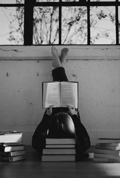 a person laying on the ground with their feet up and reading a book in front of them