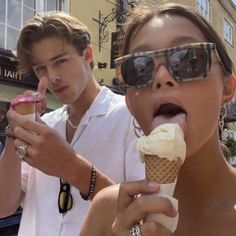 two people eating ice cream cones on the street