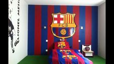 a bedroom decorated in red, blue and yellow stripes with a soccer themed wall behind the bed