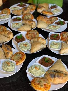 several plates filled with different types of food on top of a black tablecloth covered table