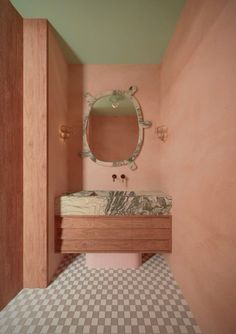 a bathroom with pink walls and checkered flooring