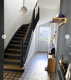 a hallway with stairs and tiled flooring next to a window on the wall above it