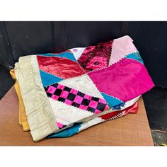 a pile of colorful blankets sitting on top of a wooden table