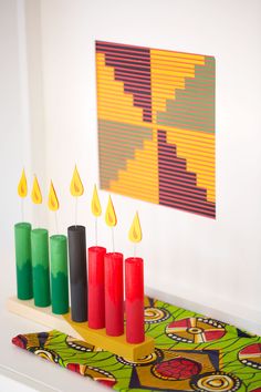 candles are lined up in front of a painting