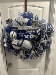 the wreath is decorated with footballs and other sports related items, as well as words cowboys welcome