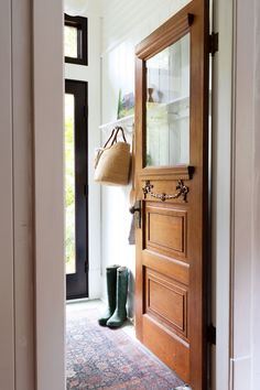 a wooden door with a basket hanging from it's side and boots on the floor