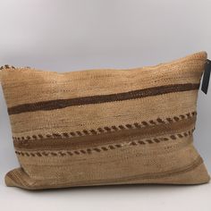 a brown and black striped pillow sitting on top of a white table