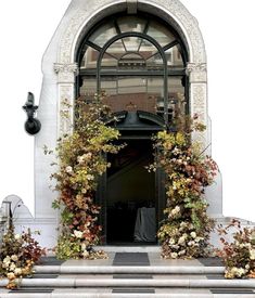 an entrance to a building with flowers on the steps