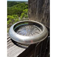 a metal bowl sitting on top of a wooden fence