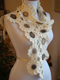 a white mannequin with a crocheted scarf on it