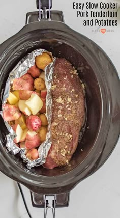 a meatloaf in a slow cooker with potatoes and tomatoes