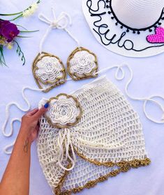 a woman is working on crochet with her hat and two pieces of clothing