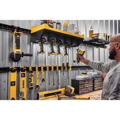 a man is working with tools on the wall in front of his workbench