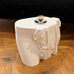 a white table with a coffee cup on it