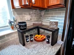 a kitchen counter that has some jars on it and a bowl with oranges in it