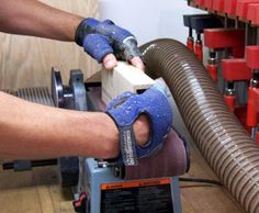 a man using a grinder on a piece of wood