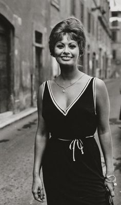 a black and white photo of a woman walking down the street