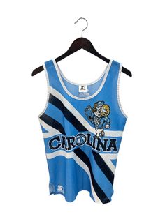 "early 90s UNC tank. by starter. carolina blue, navy, & white. sublimated graphics. side slits. 22.5\" long.  19\" across. in good, used condition. made in USA. legit. legitvintage.etsy.com legitvintage on instagram" Collegiate Sleeveless Top For Streetwear, Collegiate Fitted Sleeveless Top, Collegiate Sleeveless Fitted Top, Sleeveless Graphic Print Top For Game Day, Sleeveless Cotton Tops For Game Day, 90s Blue Sports Top, Collegiate Summer Fan Gear Tops, Collegiate Style Summer Fan Gear Tops, 90s Style Tops For Game Day During Sports Season