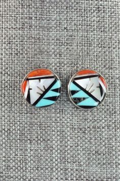 These turquoise, mother of pearl, coral, and onyx inlay sterling silver earrings were made by Zuni silversmiths Leif Esalio and M. Booqua. The back is signed MBZ.Length: 5/8"Width: 5/8"Free shipping on all orders! We ship with USPS and always include tracking. All orders ship within a day of payment.Returns are accepted up to 30 days after you receive your order. Just send us a message. Our shop offers cash back or store credit. The item must be returned in new condition. Southwestern Silver Earrings With Inlay, Silver Inlay Earrings, Silver Inlay Round Earrings, Unique Silver Earrings With Inlay, Inlay Jewelry, Zuni Jewelry, Native Jewelry, Multi Stone, Native American Jewelry