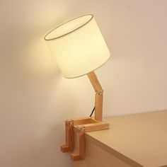 a lamp that is on top of a wooden table next to a wall mounted shelf