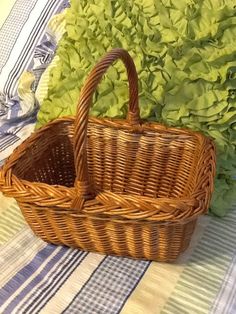 a wicker basket sitting on top of a table next to lettuce leaves