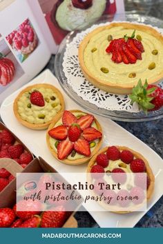 some pies and strawberries are sitting on a table with the words pistachio tart