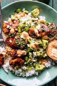 a blue plate topped with chicken and broccoli covered in sauce next to rice