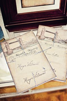 three old - fashioned postcards are sitting on a table next to a framed photograph