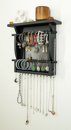 a wall mounted jewelry rack with lots of necklaces