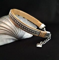 This bracelet is made with inspiration from the handcraft technique that is traditionally used by the Sami people in the north of Sweden. The bracelet is made in artificial leather which makes it wearable for vegans, and everyone else too The tin wire plait with metal beads is made seperatley and then carefully stitched on to the bracelet using a very strong but almost invisable nylon thread. The bracelet is 19 centimeters long, plus a 3 centimeter extension chain that can increase the lenght to Small Heart Pendant, Sami People, Micro Macrame, Small Heart, Artificial Leather, Metal Beads, Heart Pendant, Sweden, Gold Color