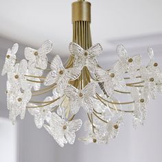 a crystal chandelier hanging from a ceiling in a room with white walls and trimmings