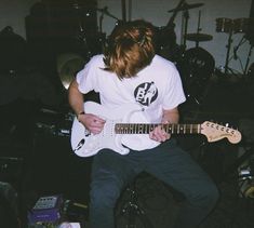 a young man is playing an electric guitar